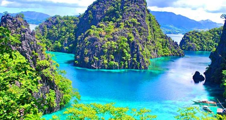 Scenic lagoon with towering limestone formations and clear blue water.