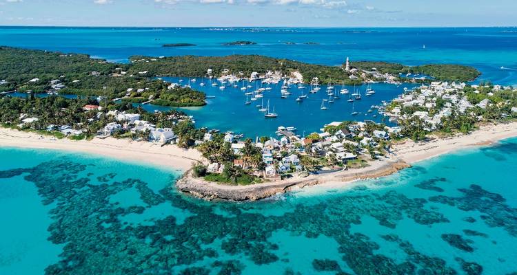 Aerial view of a coastal village with boats in the harbor.