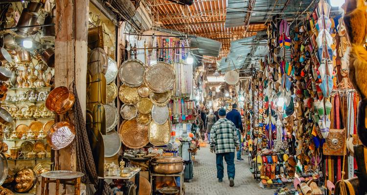 Un corredor de zoco vibrante rebosa de artículos de latón, productos de cuero y textiles brillantes en Marrakesh.