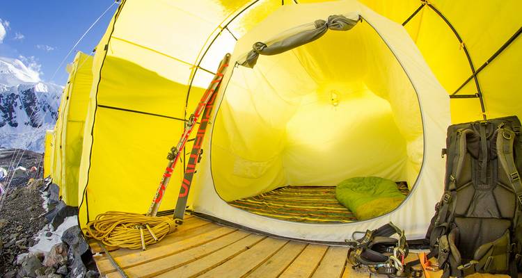 Intérieur d'une tente jaune avec du matériel d'hiver à l'intérieur.