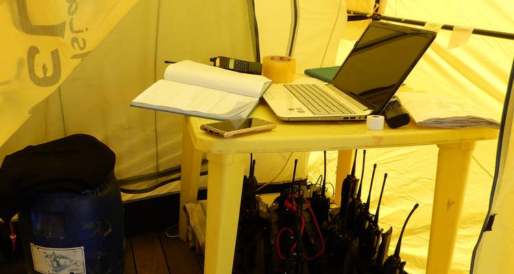 Table avec des appareils électroniques à l'intérieur d'une tente jaune.