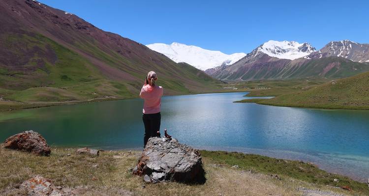Personne contemplant une vue panoramique sur un lac de montagne.