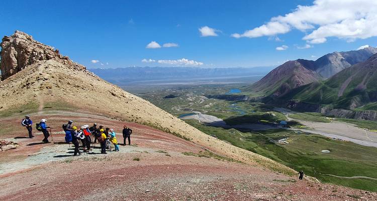 Randonneurs sur un sentier de montagne avec vue panoramique sur la vallée.