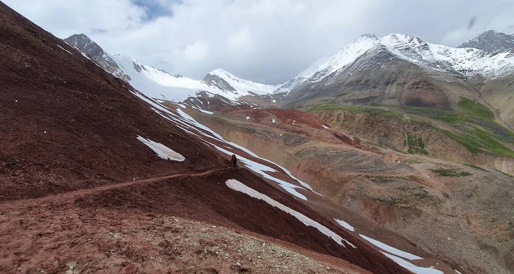 Hiking trail through mountainous terrain with snow patches