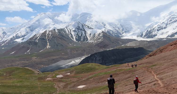 Hikers in front of a vast mountain range