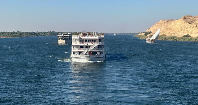 Cruiseschepen die op de Nijl varen met een zeilboot.