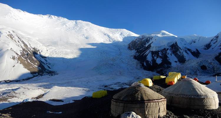 Yourtes et tentes au camp de base en montagne pendant la journée.