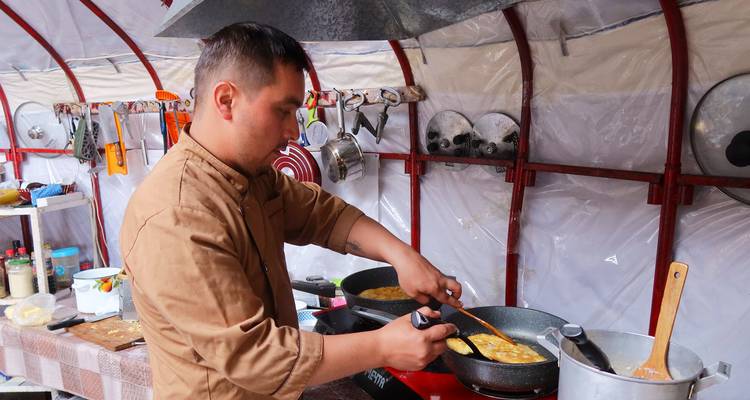 Cuisinier dans une cuisine de camp préparant de la nourriture.