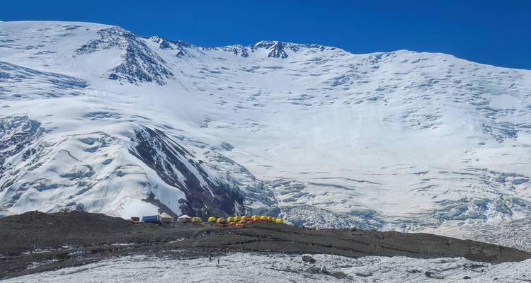 Montagne enneigée avec des tentes au camp de base.