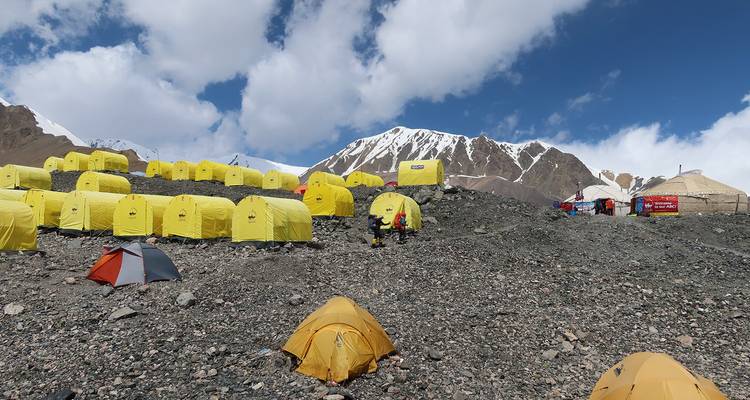 Tentes aux couleurs vives au camp de base en montagne avec des gens.