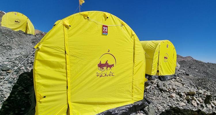 Gros plan d'une tente jaune à un camp de base en montagne.