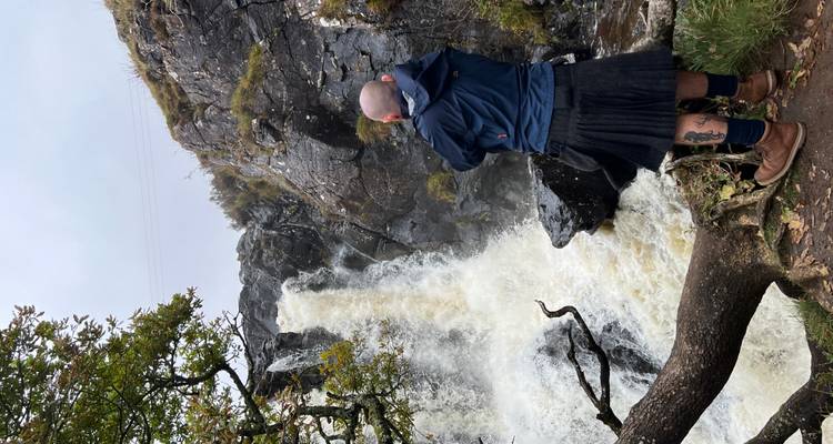 Cascada cayendo por acantilados rocosos.