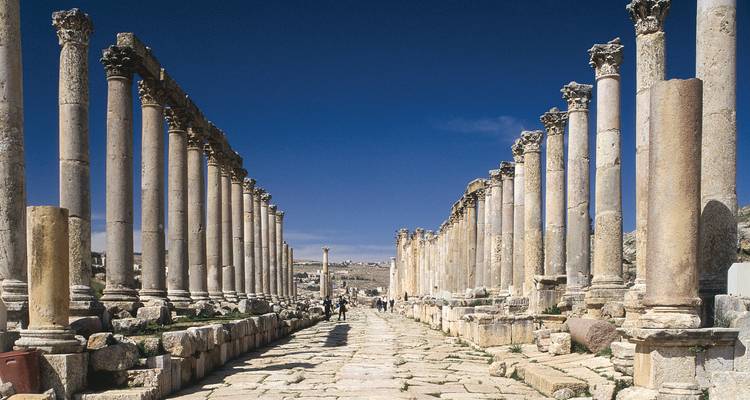 Ruinas romanas antiguas con columnas y personas.