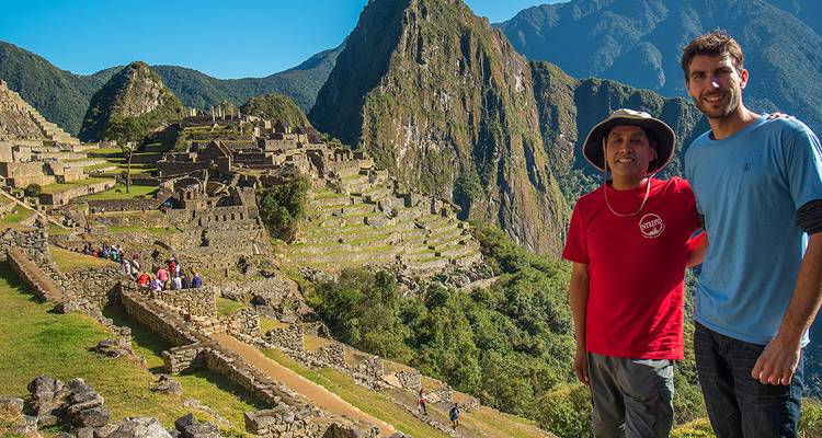Visitantes posando con Machu Picchu de fondo.