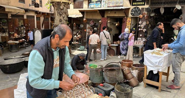 Market scene with metal artisans and shoppers.