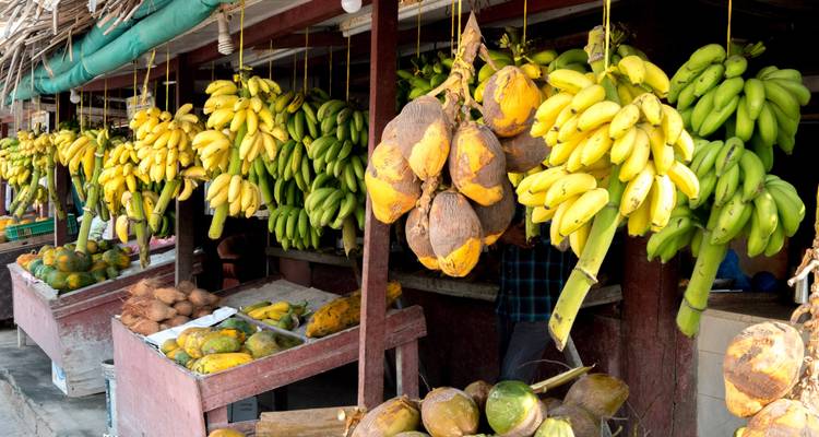 Marché de fruits avec bananes et noix de coco.