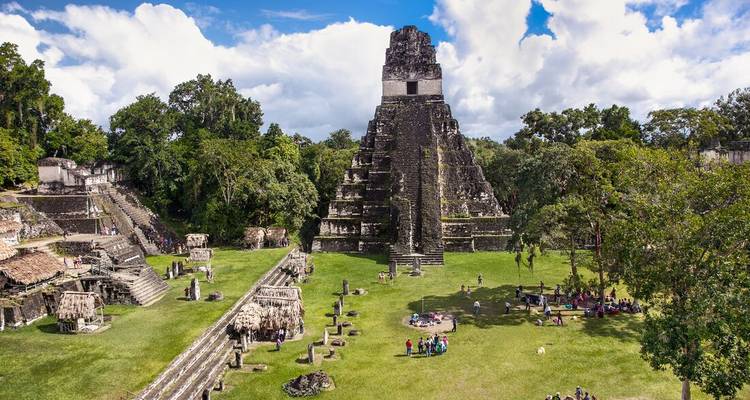 Ruines mayas de Tikal avec des personnes explorant le site.