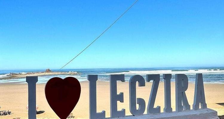 Letters die 'I love Legzira' spellen met uitzicht op een strand.