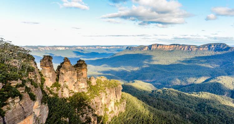 Rock formations in a vast green landscape on a sunny day.