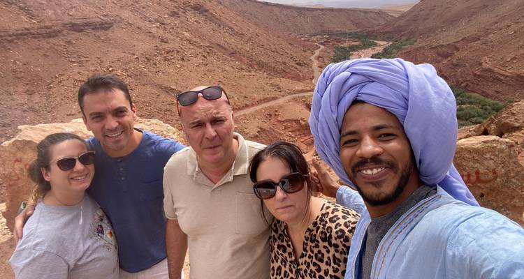 Groupe de personnes prenant un selfie avec une vallée désertique en arrière-plan.