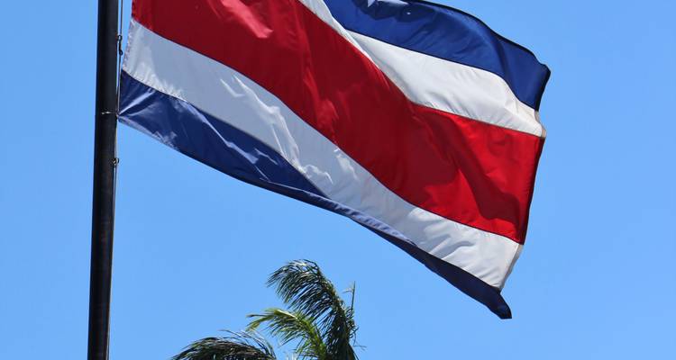 Flag of Costa Rica waving against a blue sky.