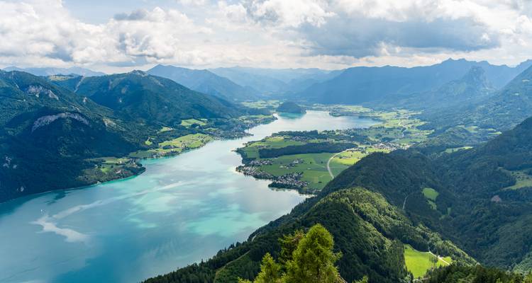 Une vue panoramique d'un lac entouré de montagnes et de vallées luxuriantes.
