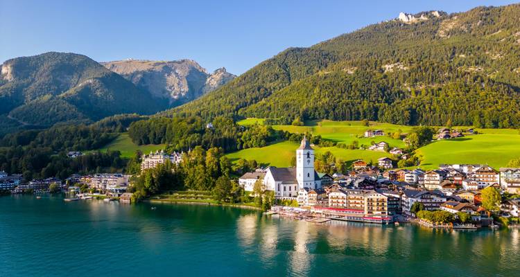 Une charmante ville au bord du lac avec une église et un décor alpin.