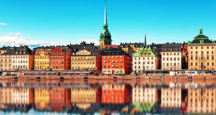 Waterfront with colorful historic buildings and reflections.