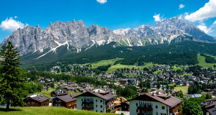 Une ville ensoleillée entourée d'une magnifique chaîne de montagnes.