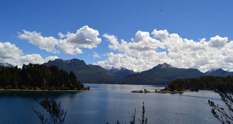 Vue panoramique sur le lac avec un ciel dégagé et des montagnes au loin.