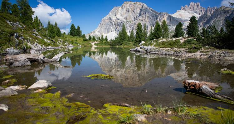 Lac réfléchissant avec toile de fond montagneuse sous un ciel dégagé.