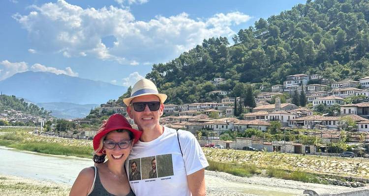 Paar posiert vor traditionellen Häusern im mediterranen Stil.