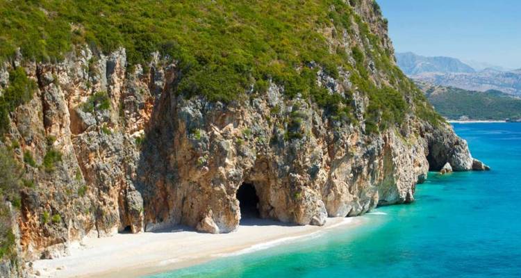 Höhle an einem abgelegenen Strand mit türkisfarbenem Wasser.