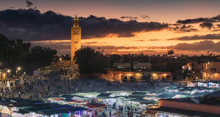 Place célèbre remplie d'étals de marché au coucher du soleil, Marrakech.