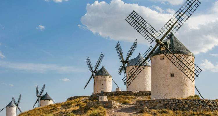 Iconic windmills in Spain against a bright blue sky.