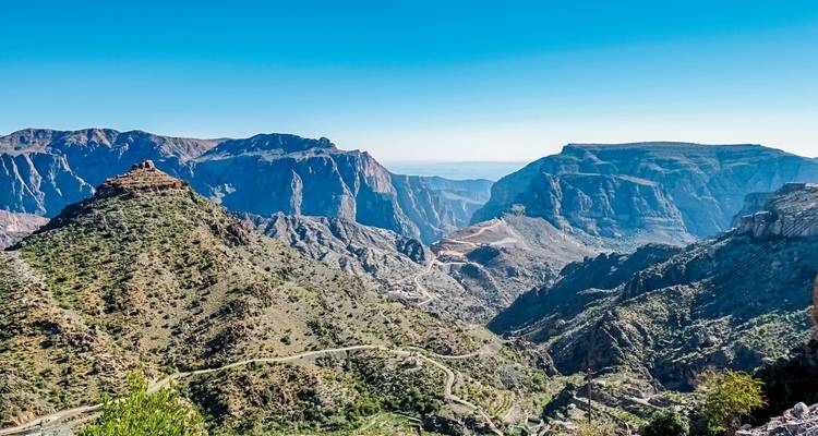 Vaste paysage montagneux sous un ciel bleu dégagé.