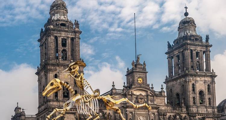 Statue eines Skeletts, das auf einem Dinosaurier vor einer Kathedrale reitet.