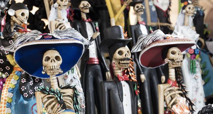 Nahaufnahme von festlichen Skelettfiguren in bunter Kleidung.