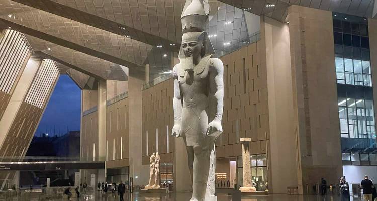 Grand intérieur de musée avec une haute statue d'un pharaon.