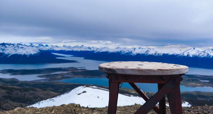 Mountain view over a fjord with an elevated platform in the foreground.