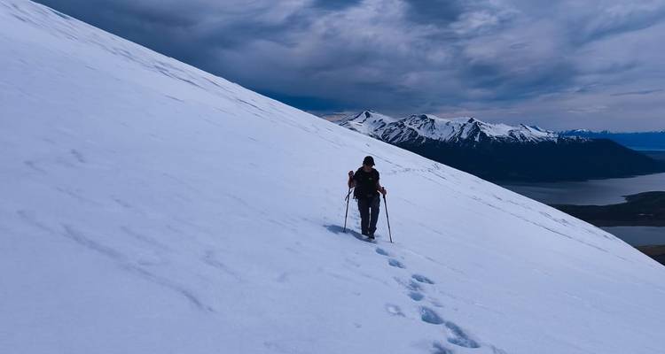 Solitary person hiking on a snow-covered mountain.