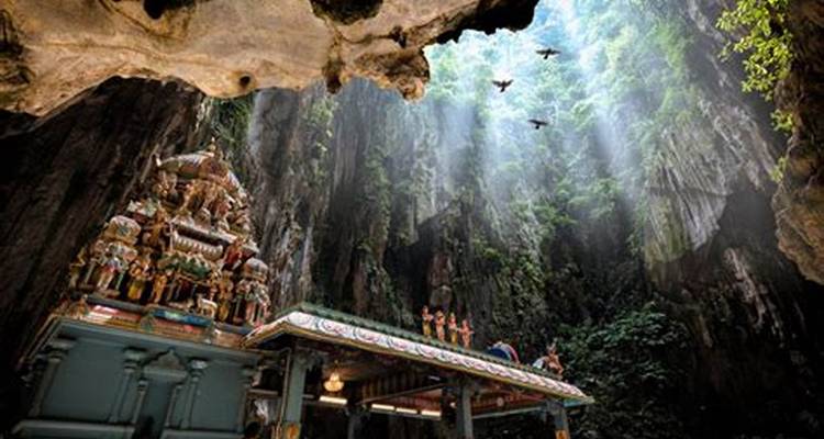 Temple à l'intérieur d'une grotte avec des rayons de soleil qui filtrent à travers.