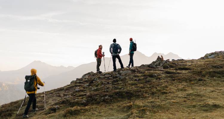 Gruppe von Wanderern auf einem Plateau mit Bergen im Hintergrund.