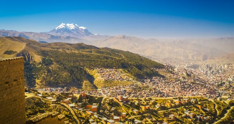 Stadsgezicht tegen een achtergrond van bergen en een met sneeuw bedekte top.