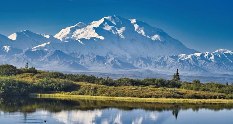Une vue magnifique d'une montagne enneigée avec un reflet dans un lac.