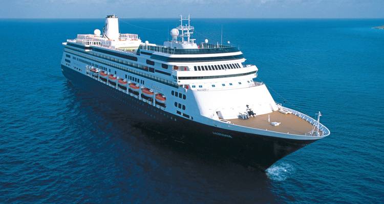 Un navire de croisière naviguant à travers l'océan sous un ciel bleu clair.