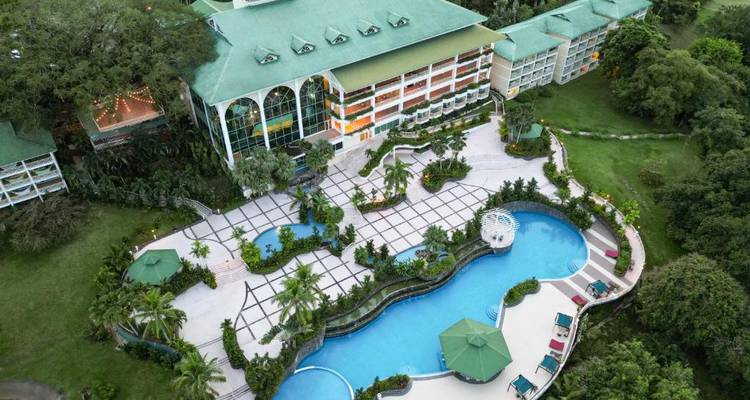 Vue aérienne d'un hôtel avec une grande piscine and jardin.