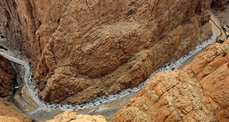 Vue aérienne d'une gorge rocheuse avec des voitures garées.