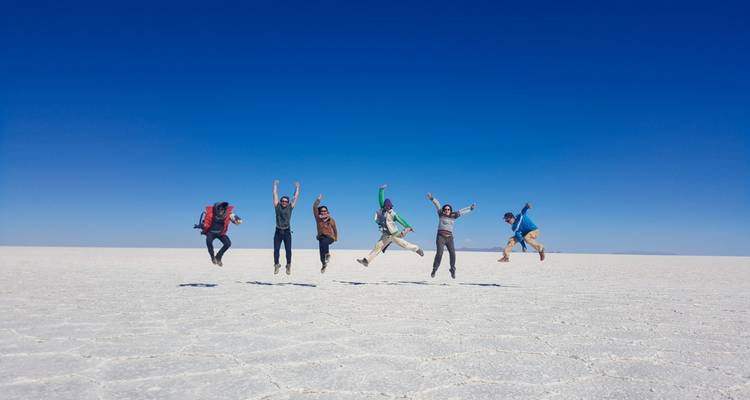 Group of people jumping in celebration on the Uyuni Salt Flats.