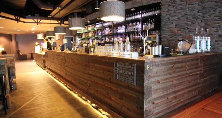 Bar avec comptoir en bois et diverses boissons.